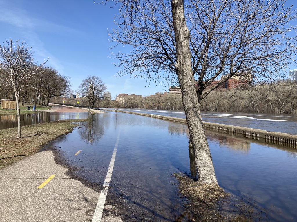 a walking and biking trail half flooded with river water