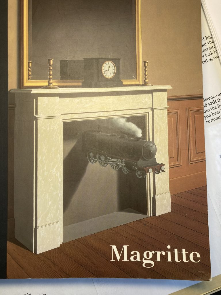 The cover of Magritte book. At the center, a fireplace with a black train, steam coming out of the top, emerging from its center. On the mantel, a clock. And behind that, a big mirror. In the bottom right corner, the book title: Magritte